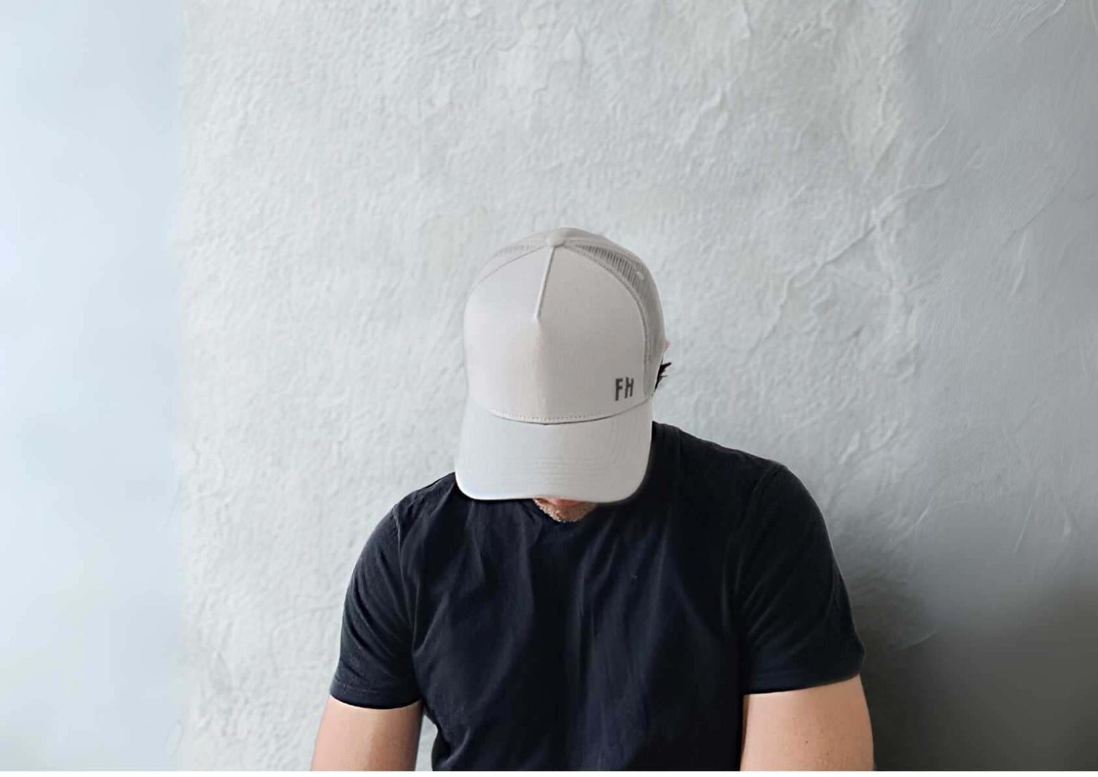 Hombre con gorra trucker hat XL gris y camiseta negra, ideal para cabezas XL en la guía de gorras grandes.